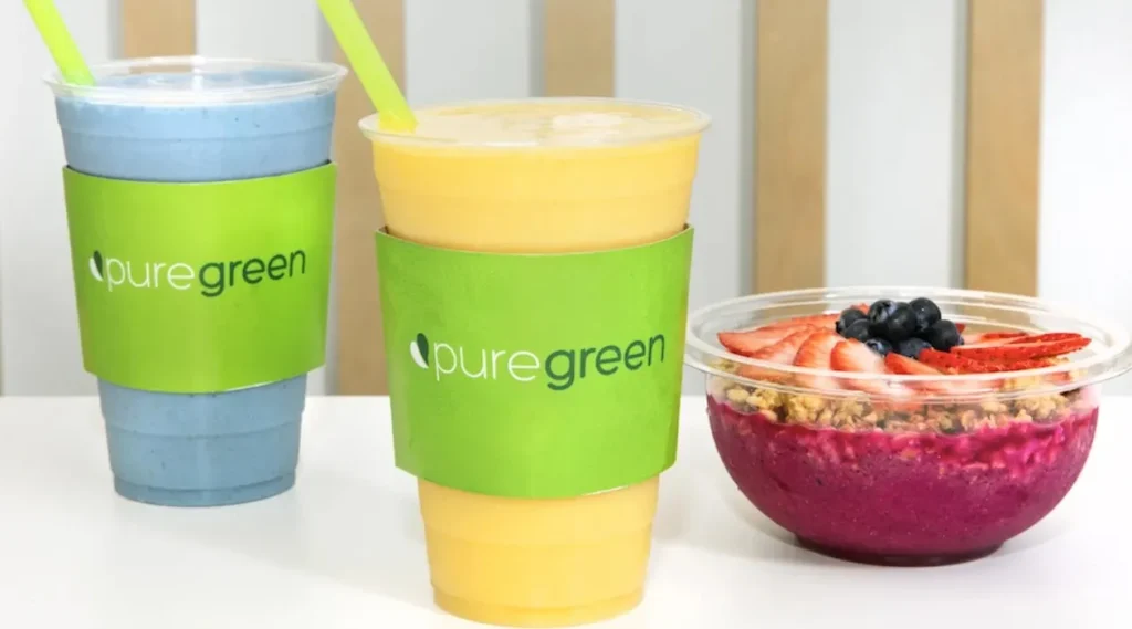 2 Pure Green smoothie drinks and 1 acai bowl on a table