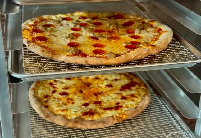 2 stacked pizzas on baking tins