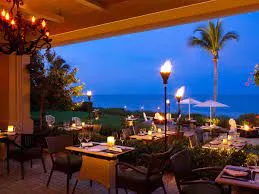 Baleen restaurant patio with tiki torches overlooking the Gulf