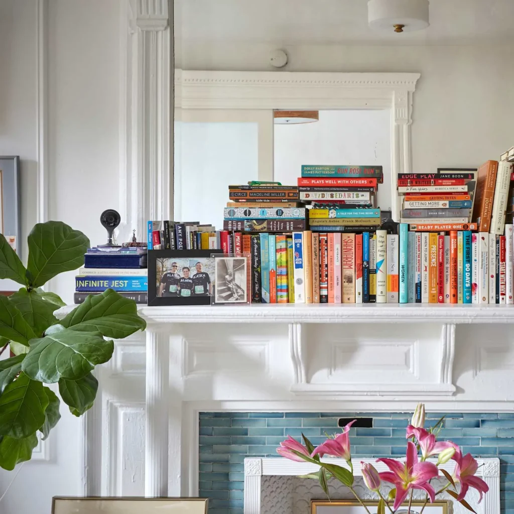 Books stacked on a fire place.