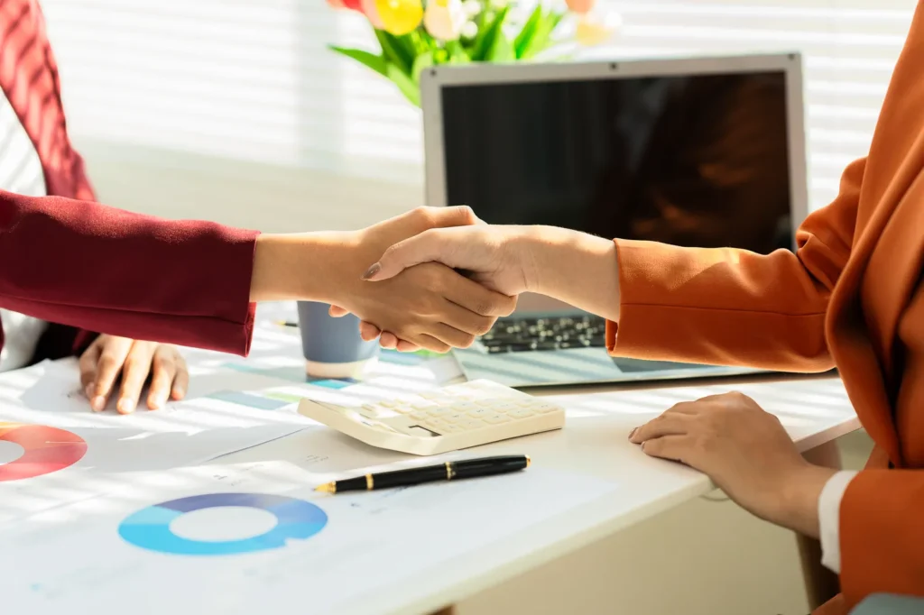 Business handshake across a desk after a negotiation
