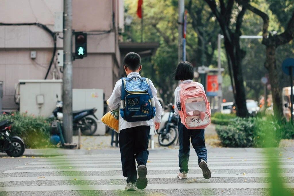 Two children with backpacks walking to school