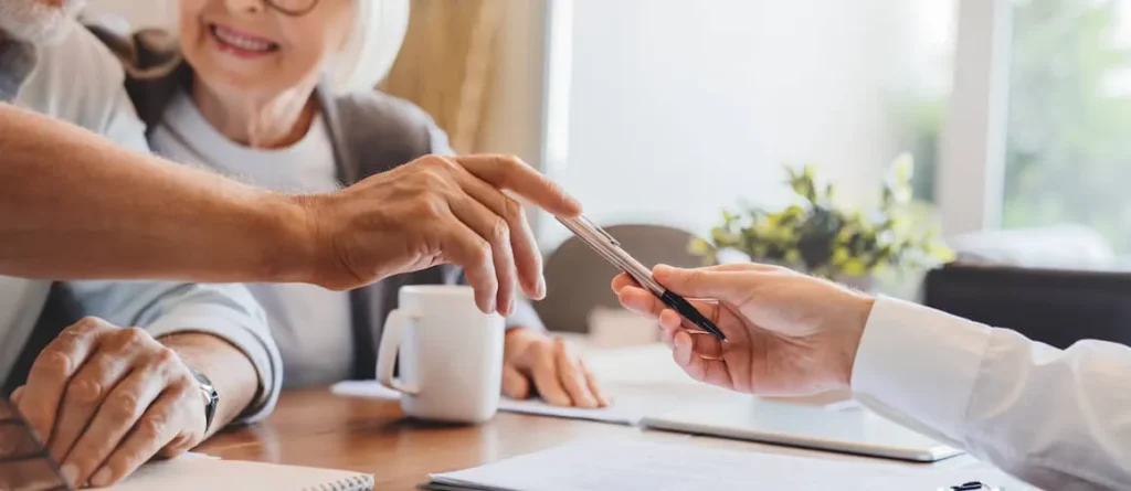 Client signing a real estate contract with a pen at a table