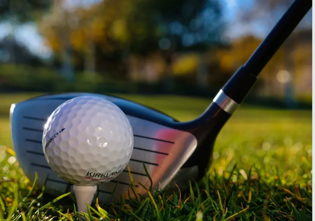 Close up of golf ball on tee and golf club ready to hit