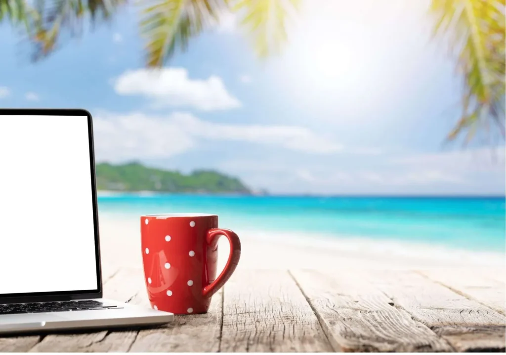 Coffee cup and laptop with view of beach