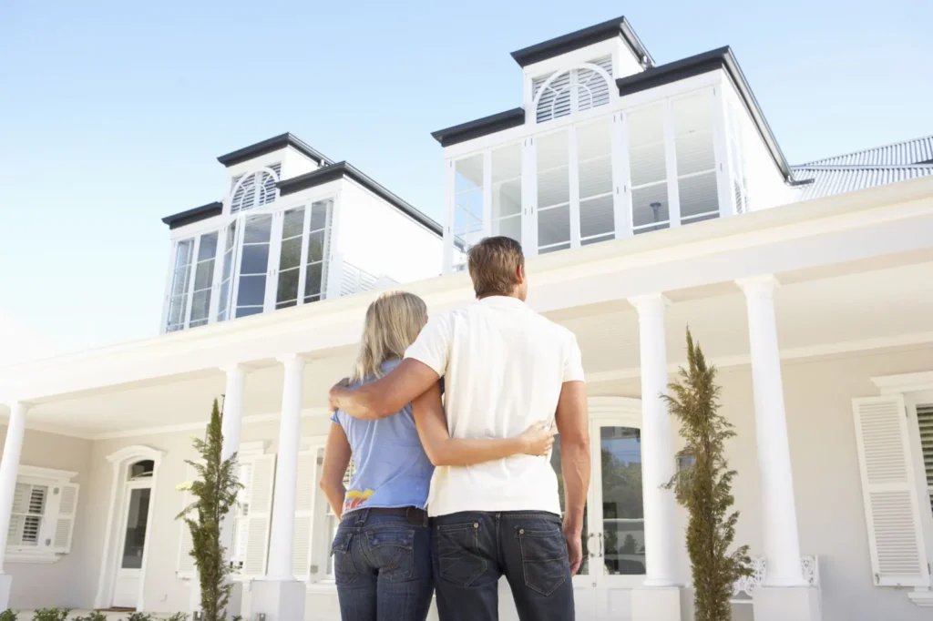 Couple standing in front of their dream house