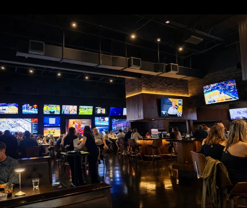 Crowded sports bar room with wall-to-wall TVs at The Tipsy Corner