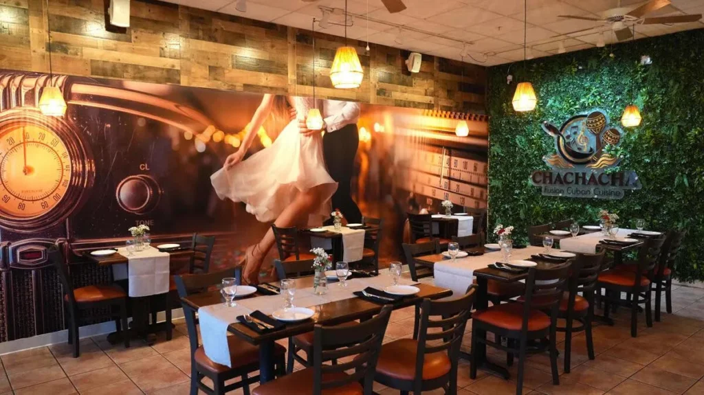 Dining room with dance mural and greenery wall at ChaChaCha Cuban restaurant