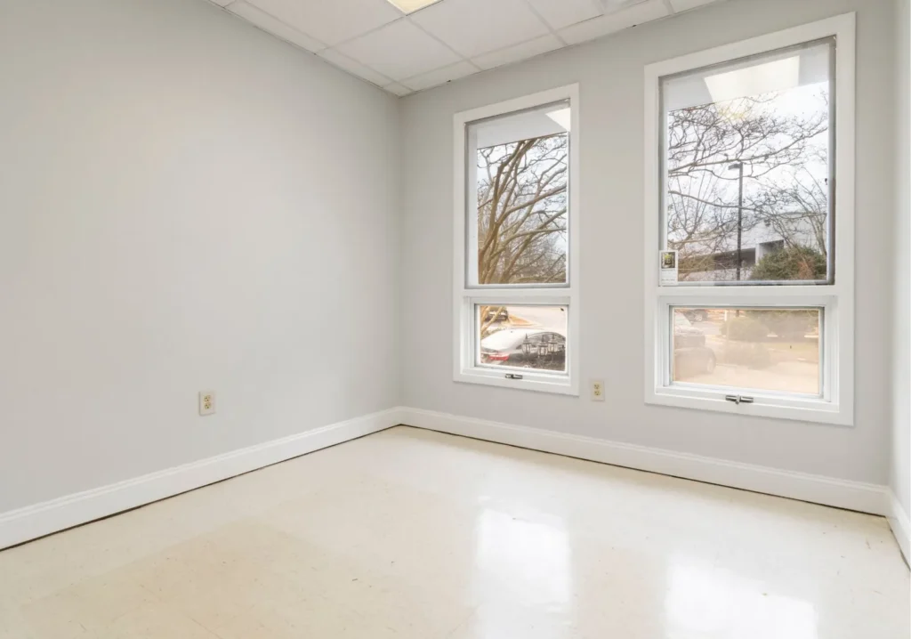 Empty unfurnished bedroom with white walls and tile floor