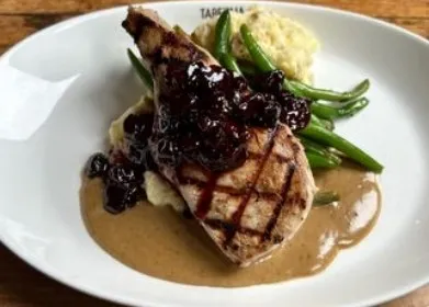 Grilled pork chop with berry sauce and green beans at Taberna Burntwood