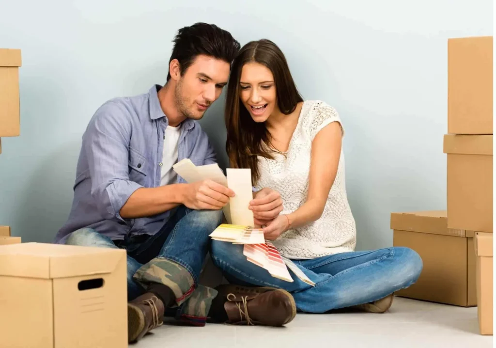 Happy Couple choosing paint colors around moving boxes