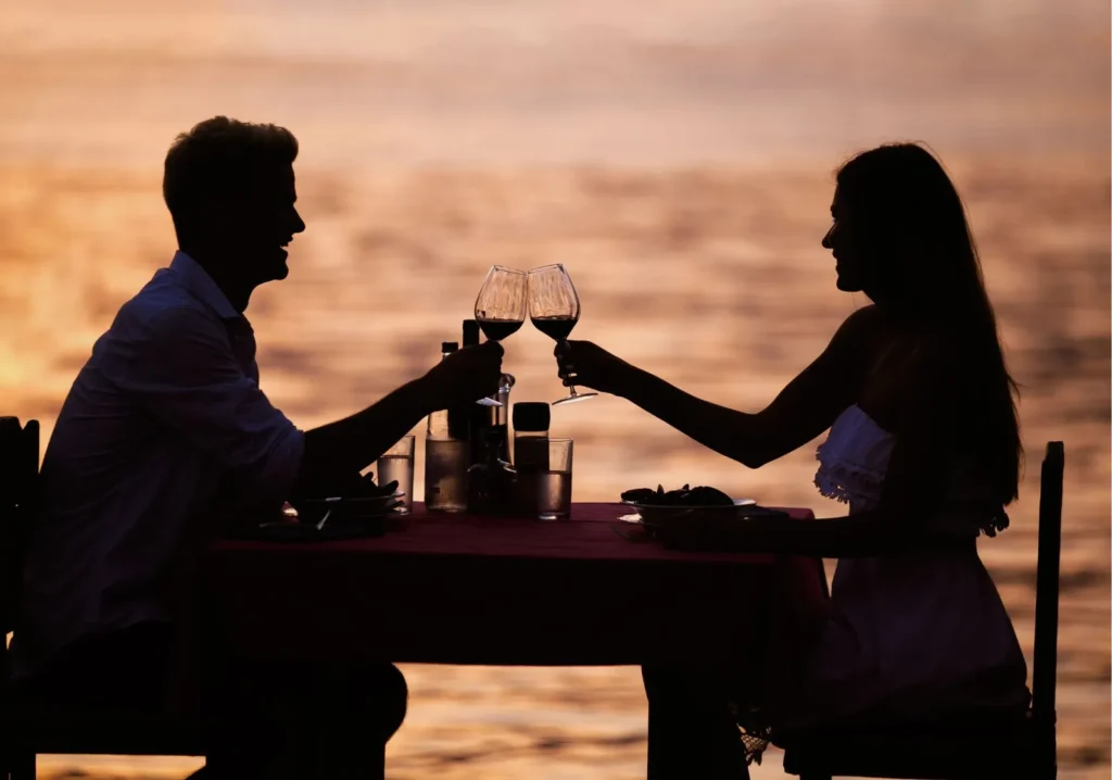 Happy couple dining outdoors at sunset