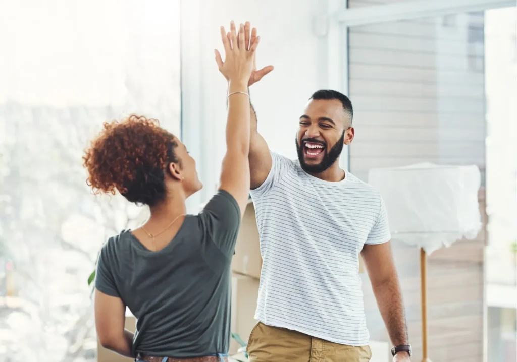 Happy home buying couple high fiving