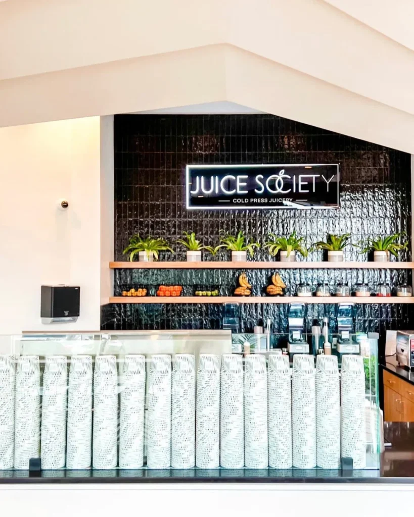 Juice Society storefront interior with neon logo and seating
