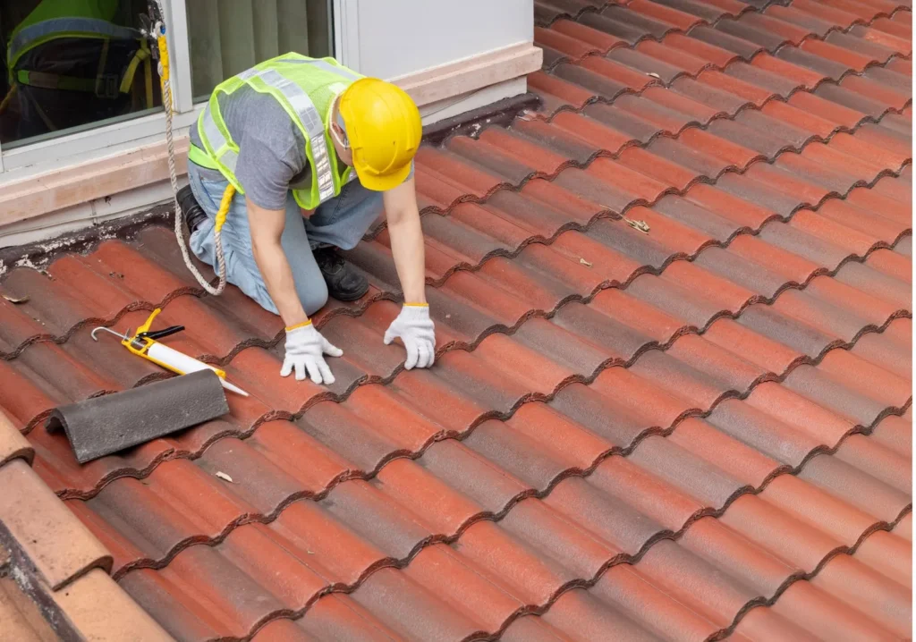 Man repairing roof tiles