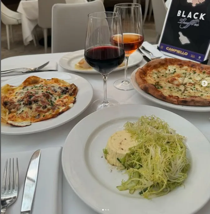 Multiple dishes served on a table with a white tablecloth