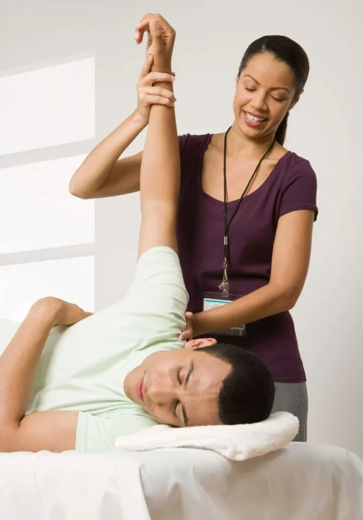 Physical Therapist helping young teen with rehabilitation on arm