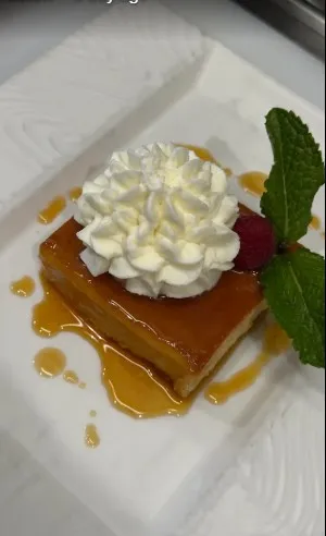 Plated dessert with whipped cream and mint at Paella's