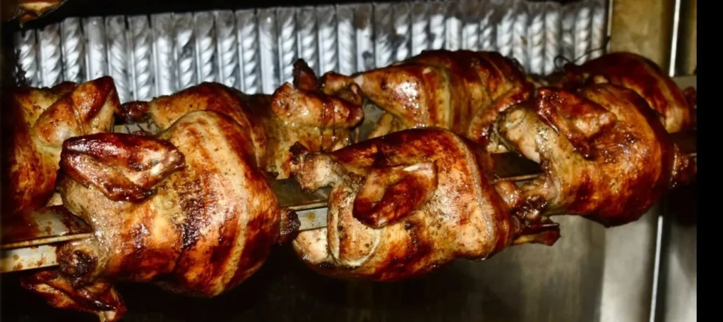 Rotisserie chickens roasting at D'Peru restaurant