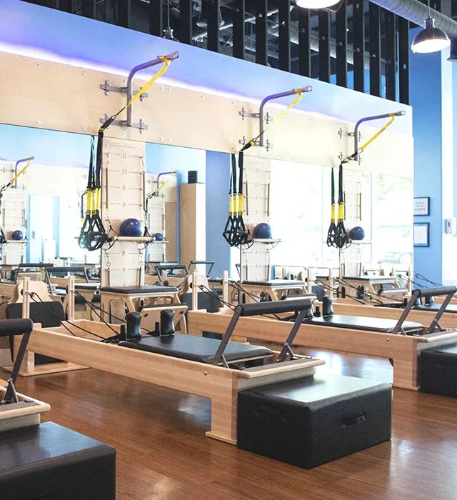 Row of reformer machines at Club Pilates in Naples