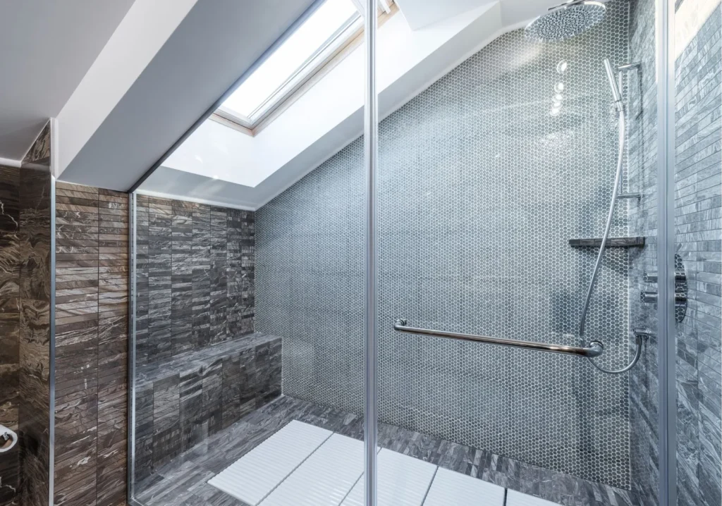 Seamless modern glass shower stall with gray tiles