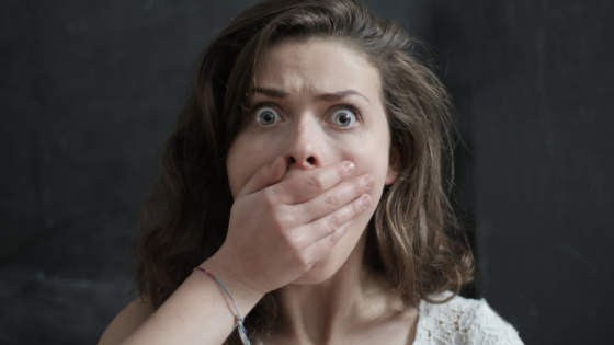 Startled woman covering her mouth