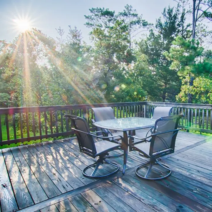 Sunlit wood deck with patio table and chairs