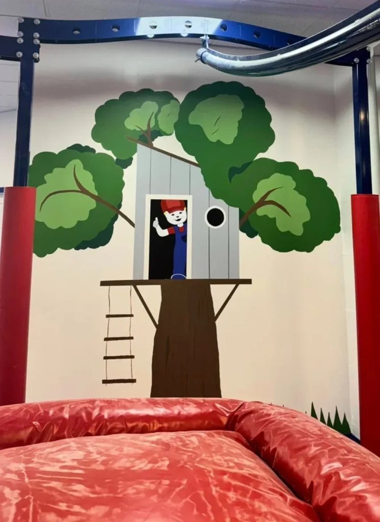 Treehouse mural in the play area at We Rock the Spectrum Naples