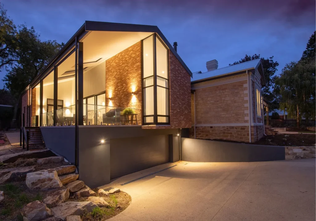 Twilight shot of home from the outside looking into room with large windows