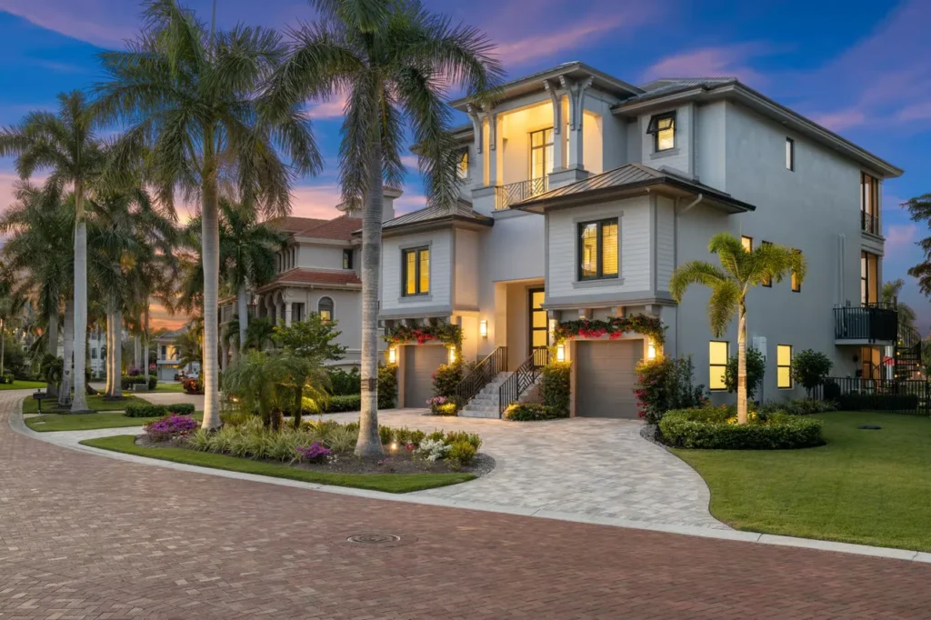 Two-story Naples home with landscaped front yard at dusk