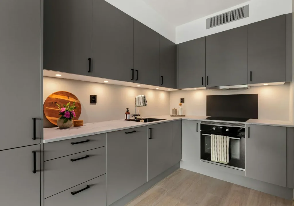 Under cabinet lighting in a sleek modern gray kitchen
