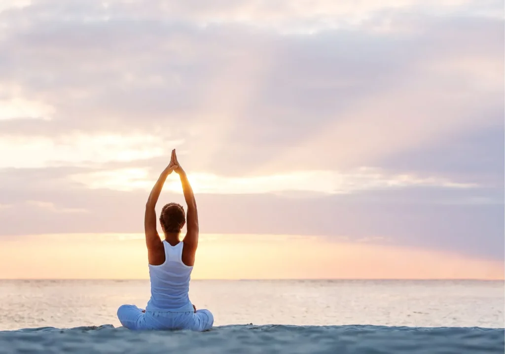 Woman doing yoga on the beach