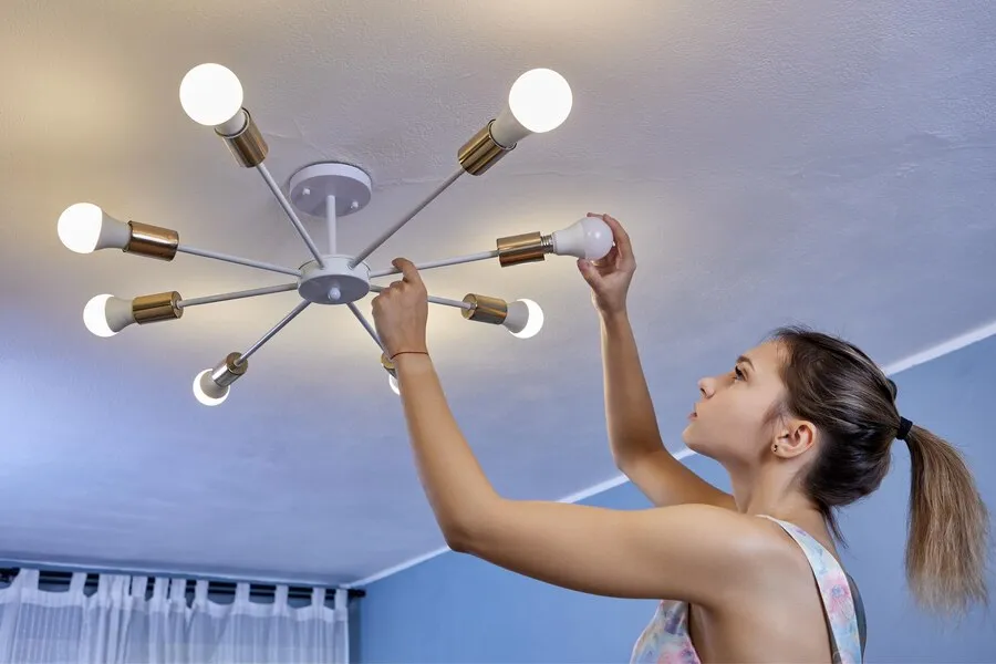 Woman installing a contemporary light fixture