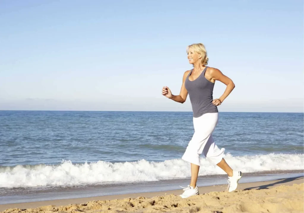 Woman running along the beach shoreline