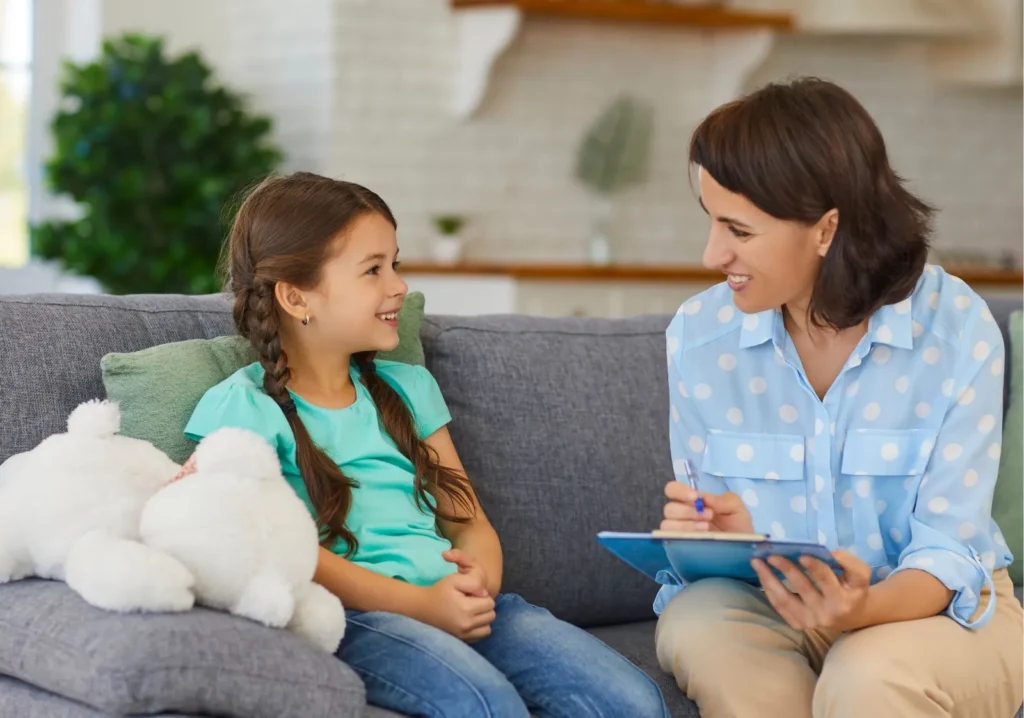Woman speaking with young female child on a sofa