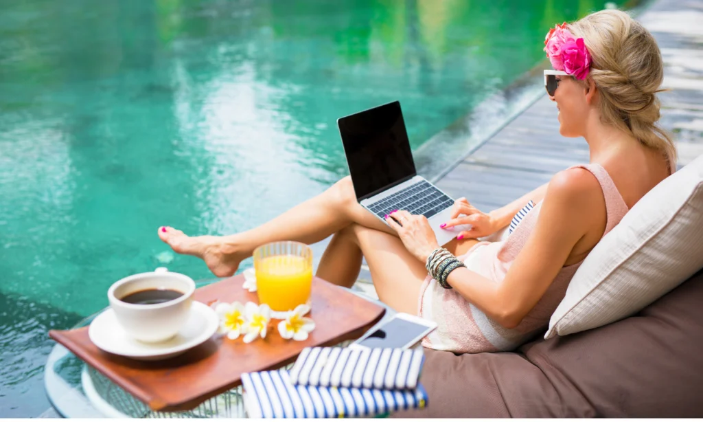 Woman working on a laptop poolside