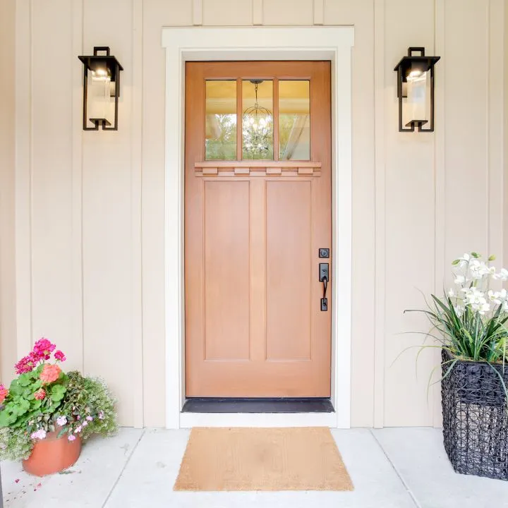 Wood front door with lanterns and potted flowers