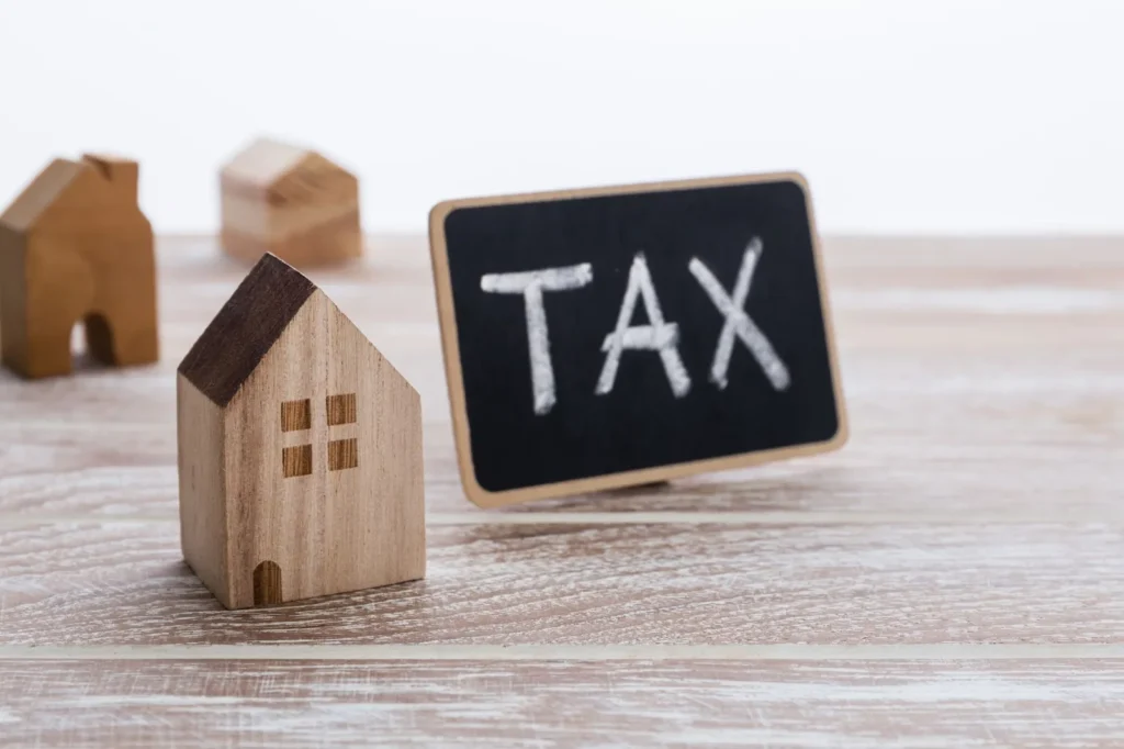 Wooden house beside a tax sign