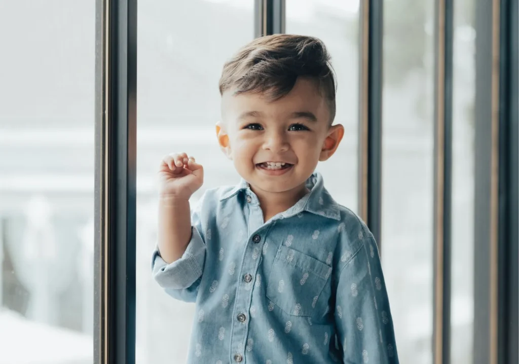 Young boy holding up his fist and smiling