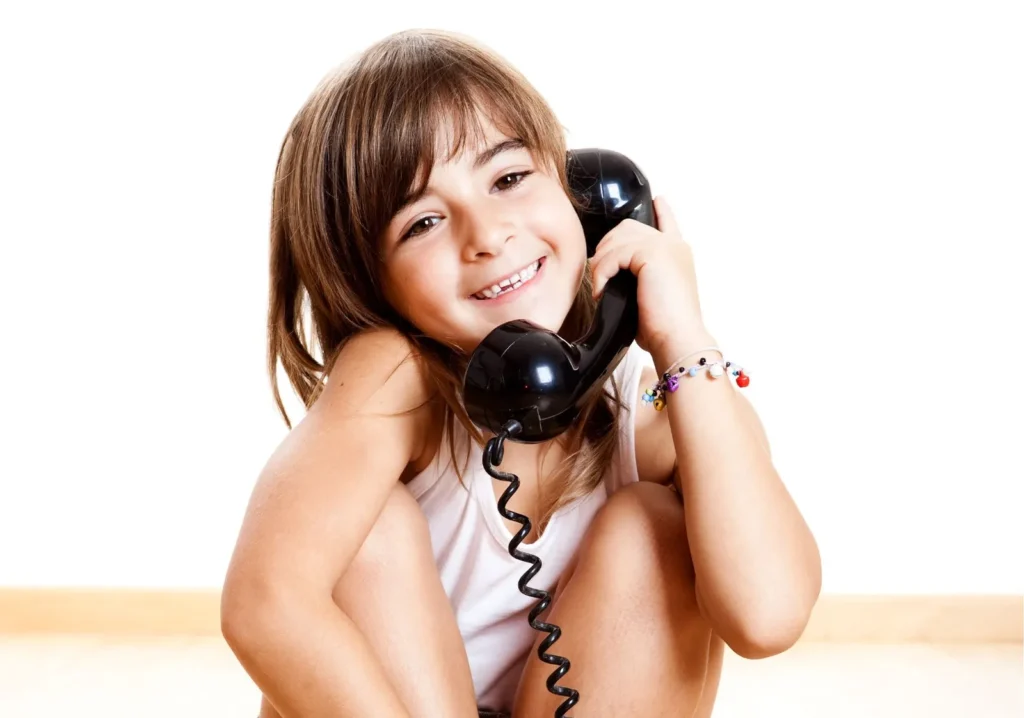 Young girl holding vintage black phone receiver