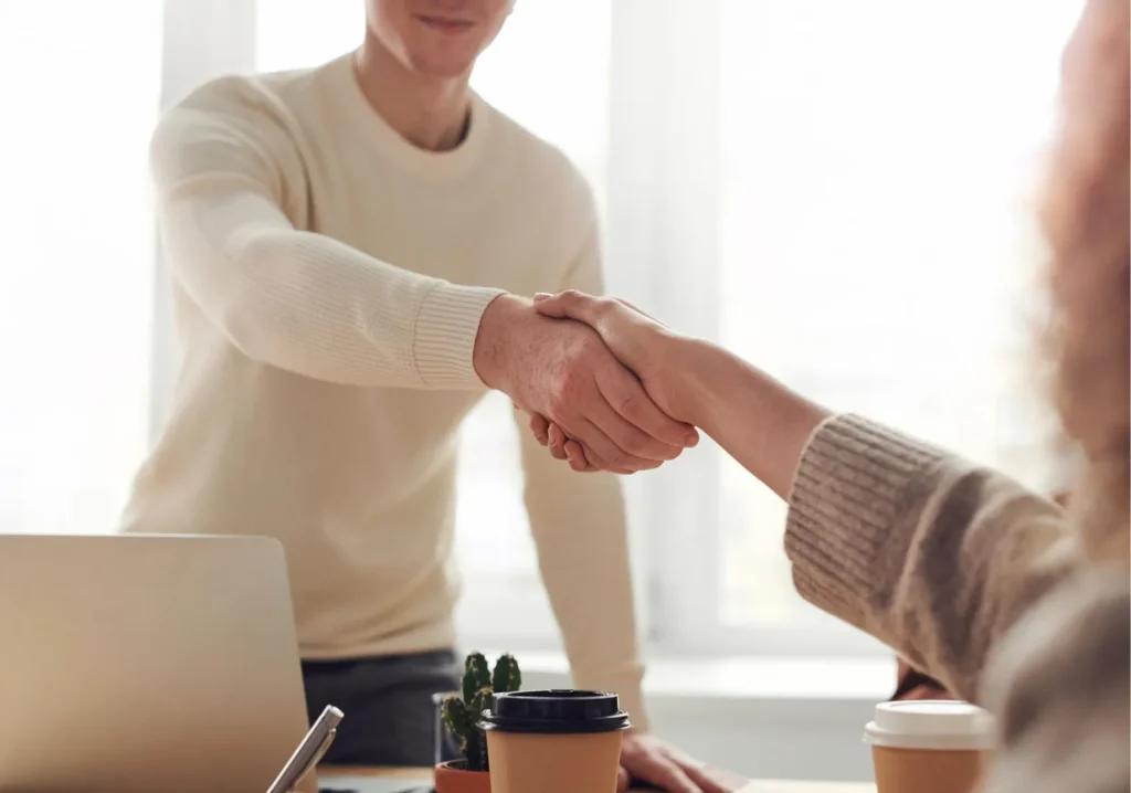 Young man shaking hands with female agent